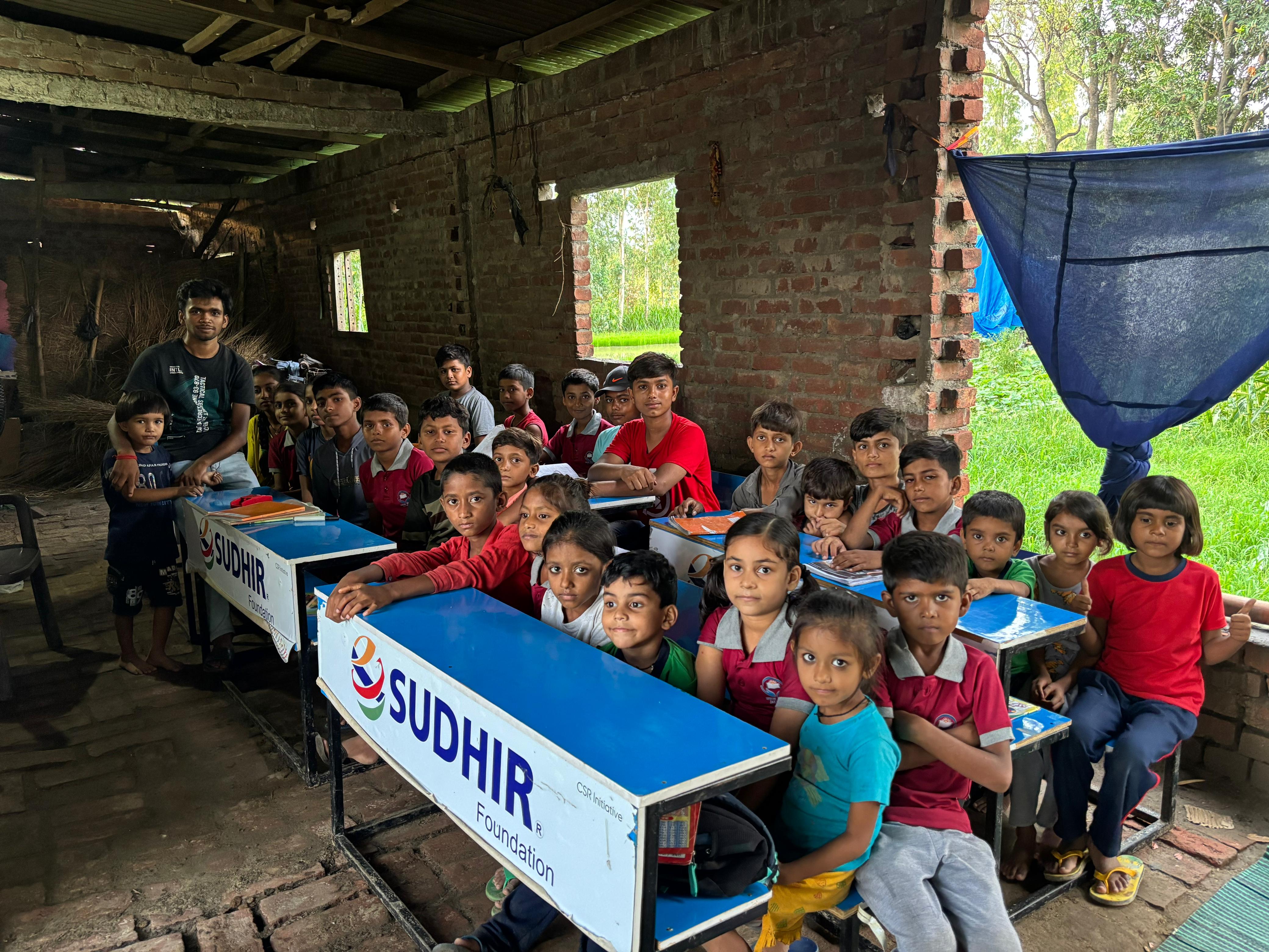 Aditya sitting on bench, with students